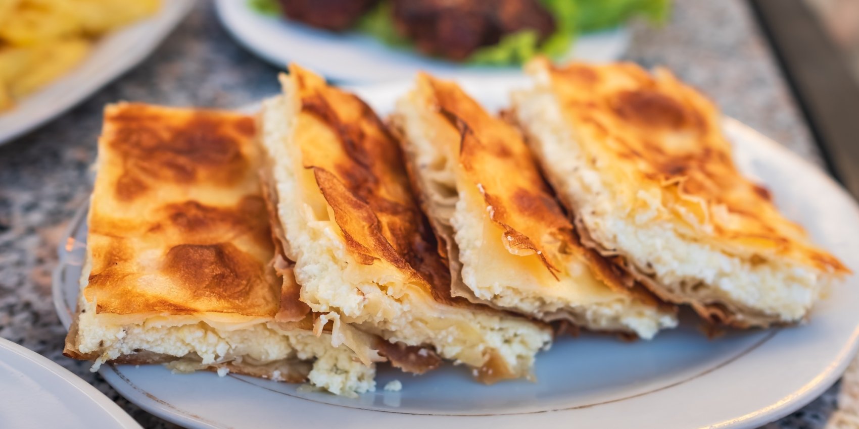 A flakey Albanian pastry, Byrek, plated after being freshly made.