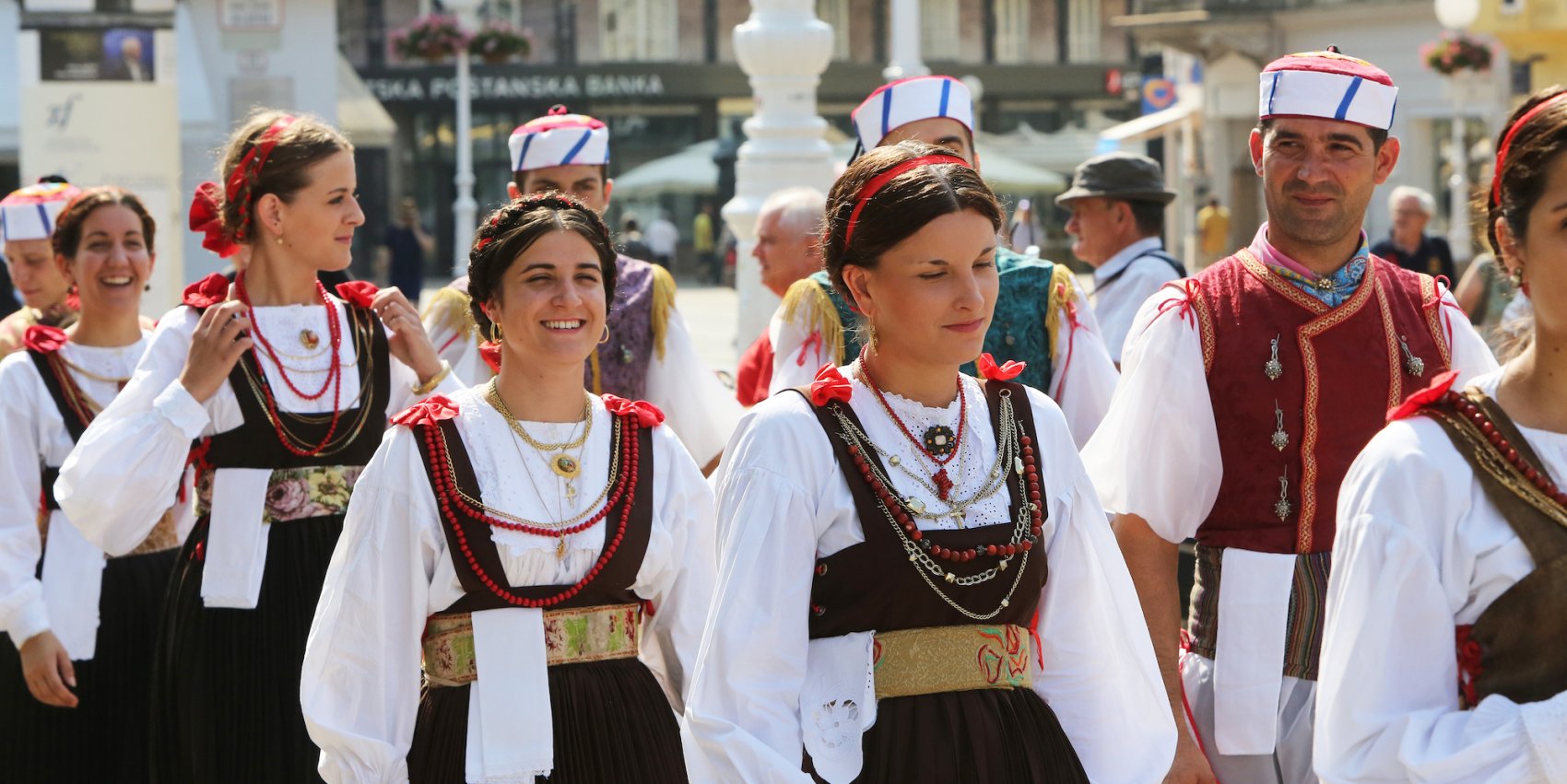 A group of people dressed in traditional Croatian attire attending a cultural heritage festival