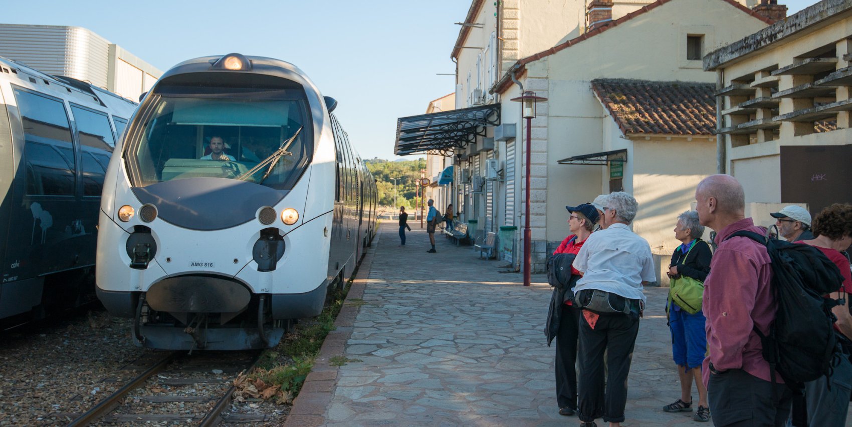 People boarding a new and sleek train in Europe on a sunny summer day