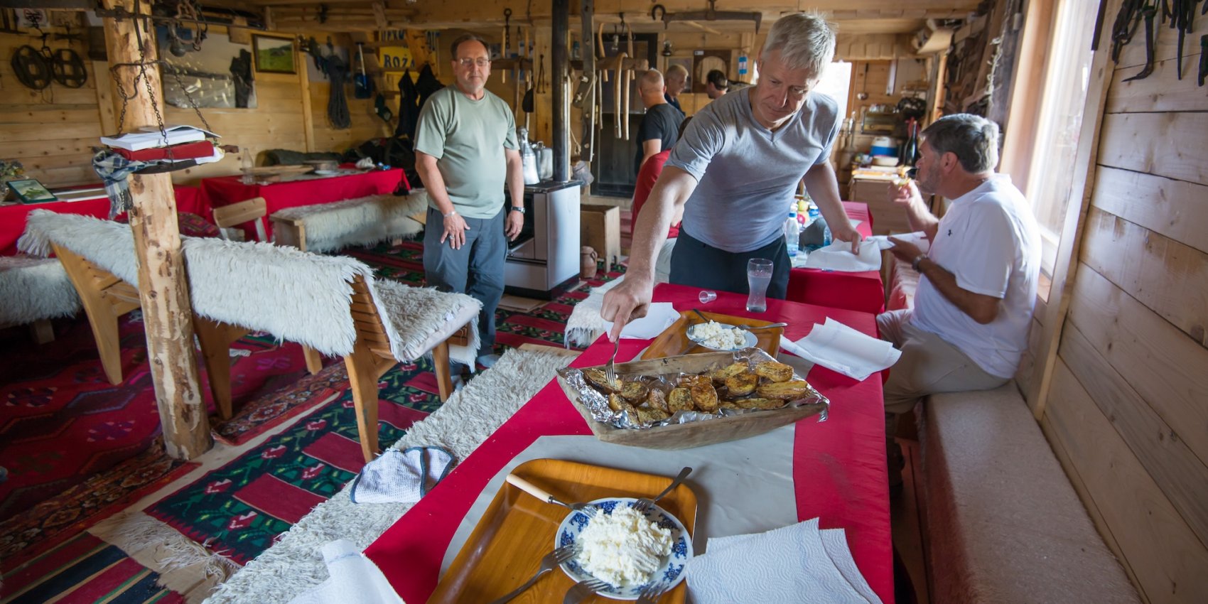 A group of travelers sharing a meal in an Albanian home.