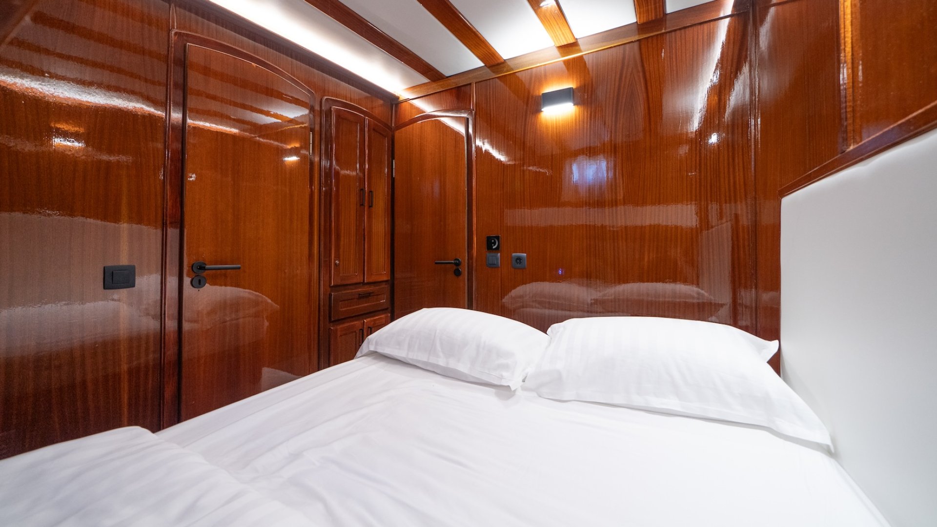 A yacht interior cabin with a neatly made bed.
