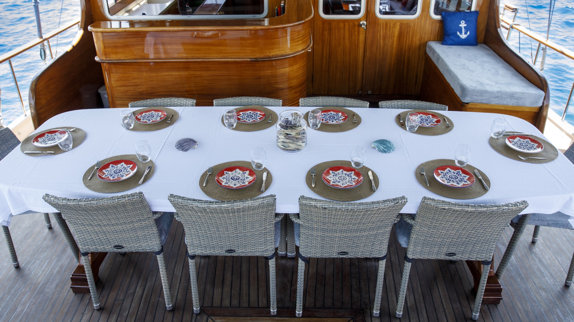 A long rectangular table with a white table cloth and traditional Turkish place settings on a yacht deck in Turkey