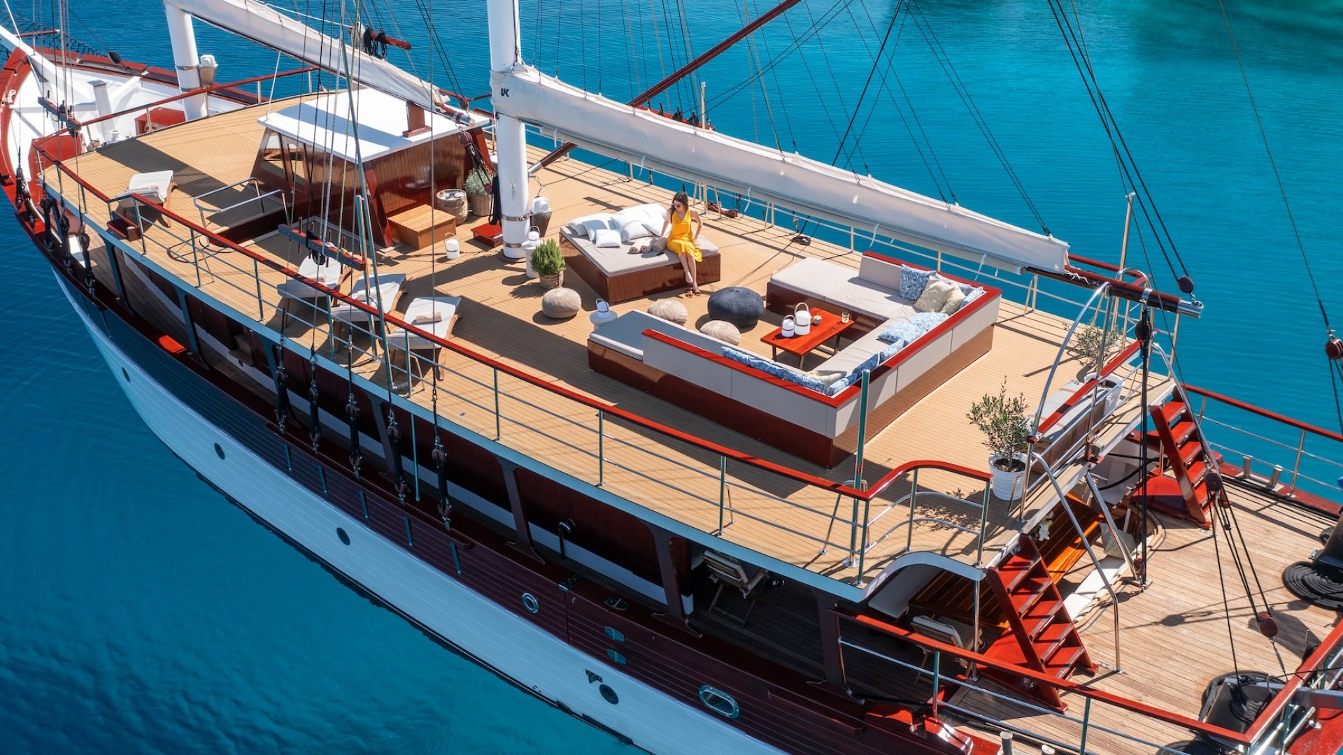 The sun deck of a sailing yacht anchored in blue waters off of the coast of Croatia.