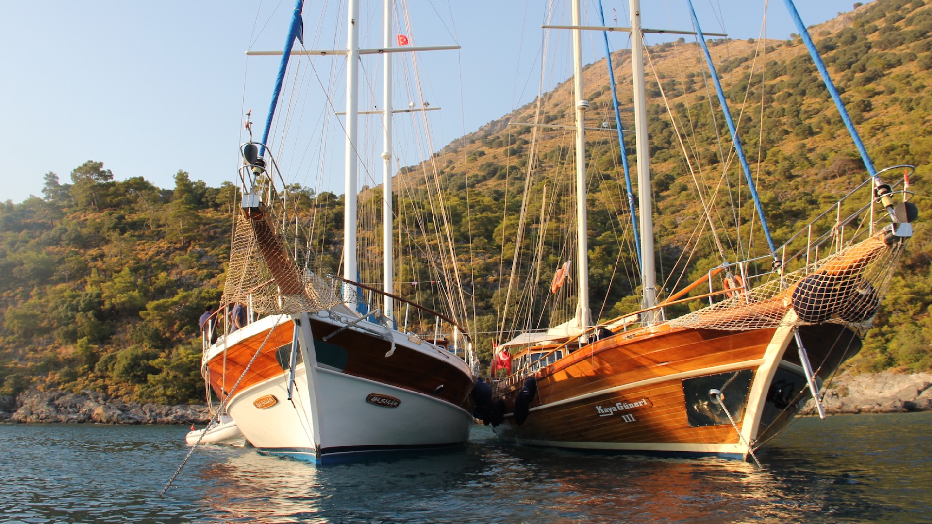 Picture from the water of the bow of two small sail ships used for chartered yachting tours in Turkey