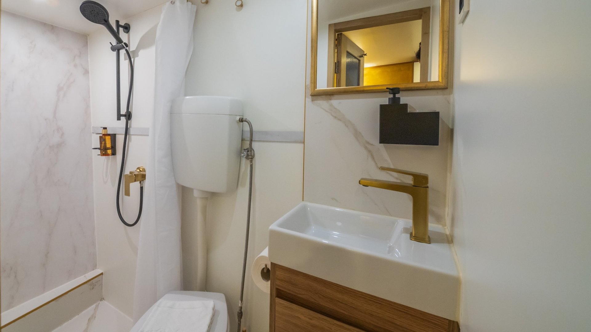 A yacht bathroom with a shower, sink, and toilet.