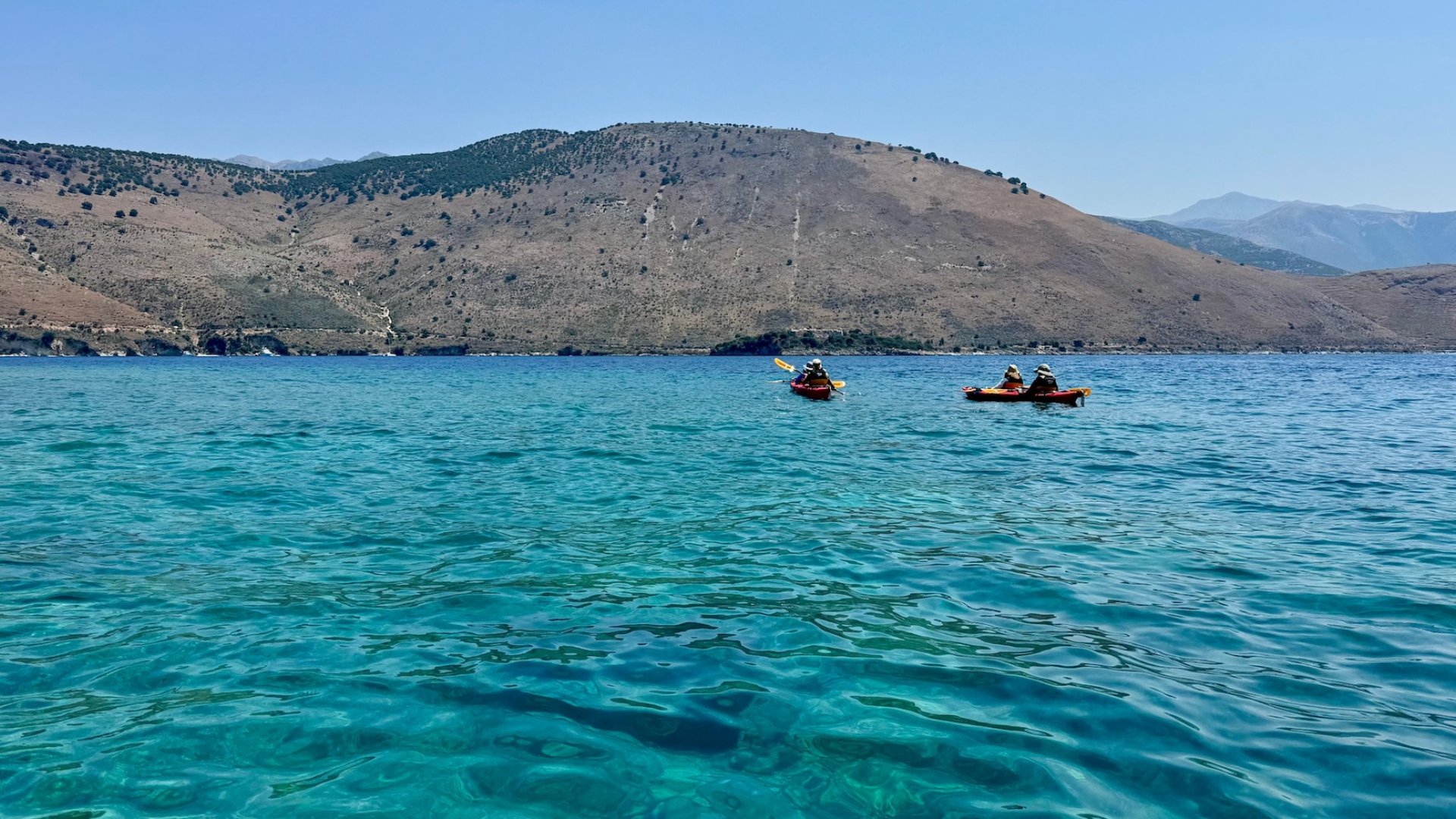 A group of sea kayakers exploring the Albania coastline on a guided tour in Europe.