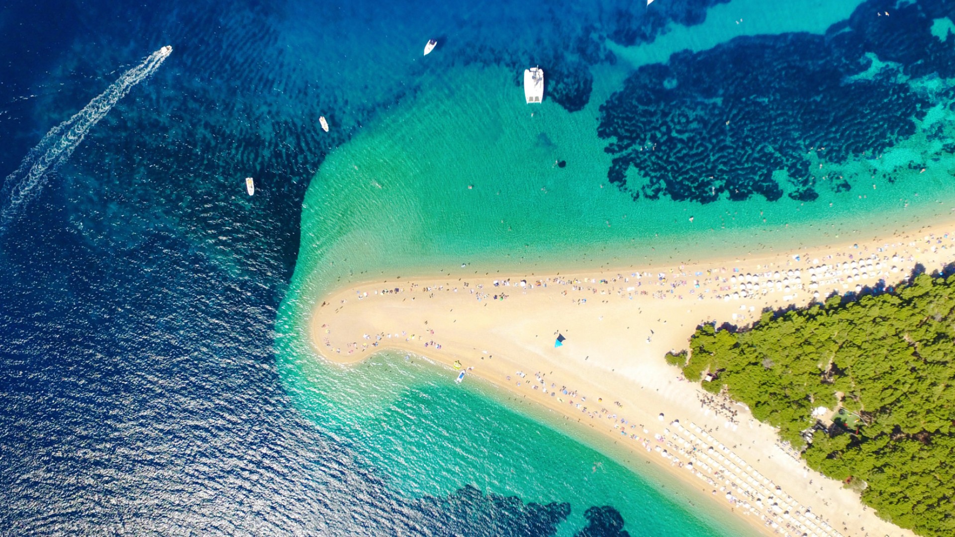 Birds eye view of an empty sandy beach with crystal clear turquoise water in Croatia