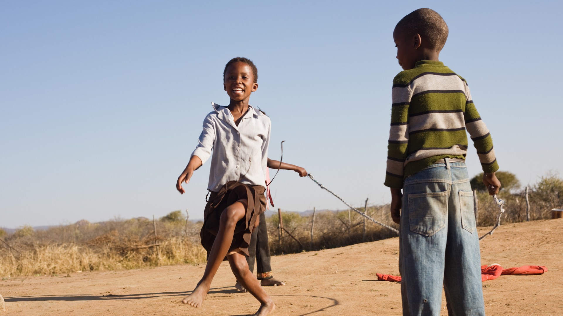 Two kids dancing in the dirt in Botswana