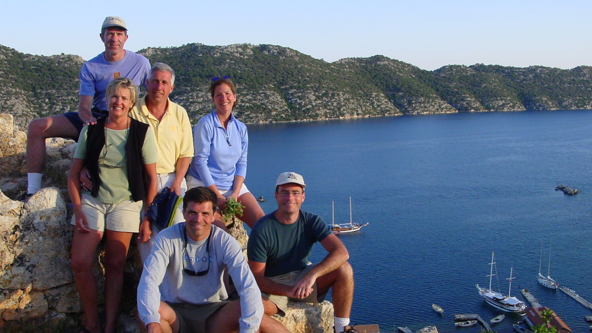 A group of tourists standing and smiling at an overlook of the sea in Turkey