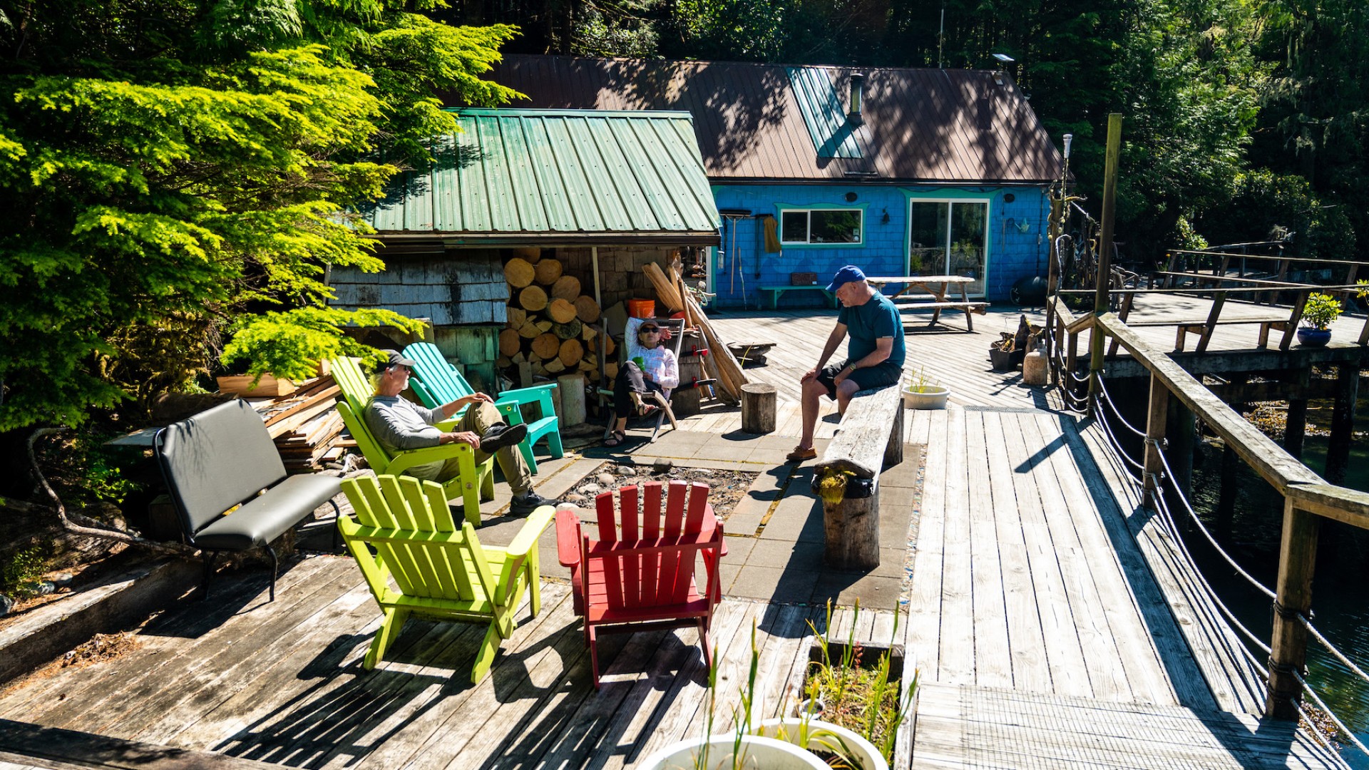 People sitting in colorful plastic lawn chairs on a deck at God's Pocket Resort in British Columia