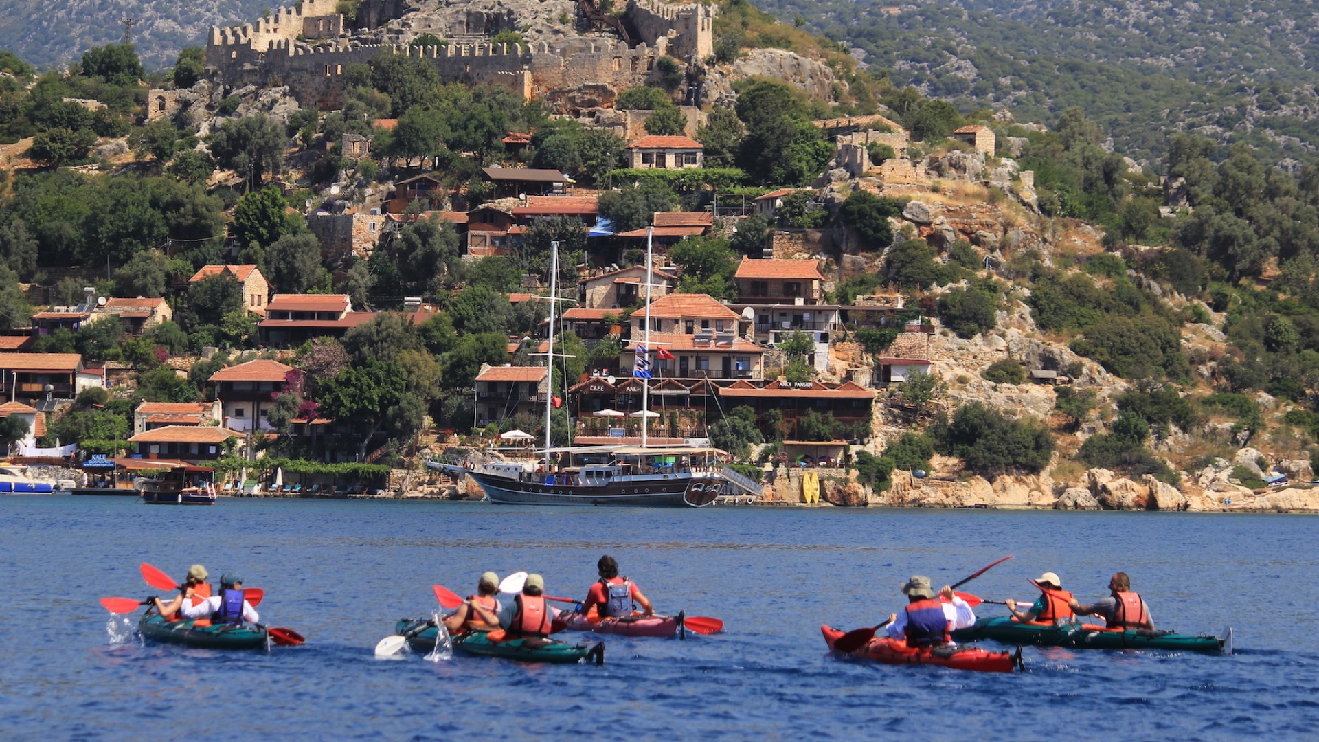 Kayaking towards a hillside town on the Carian Coast in Turkey