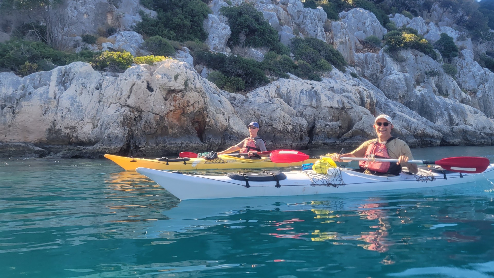 Happy guests paddling single kayaks in Turkey