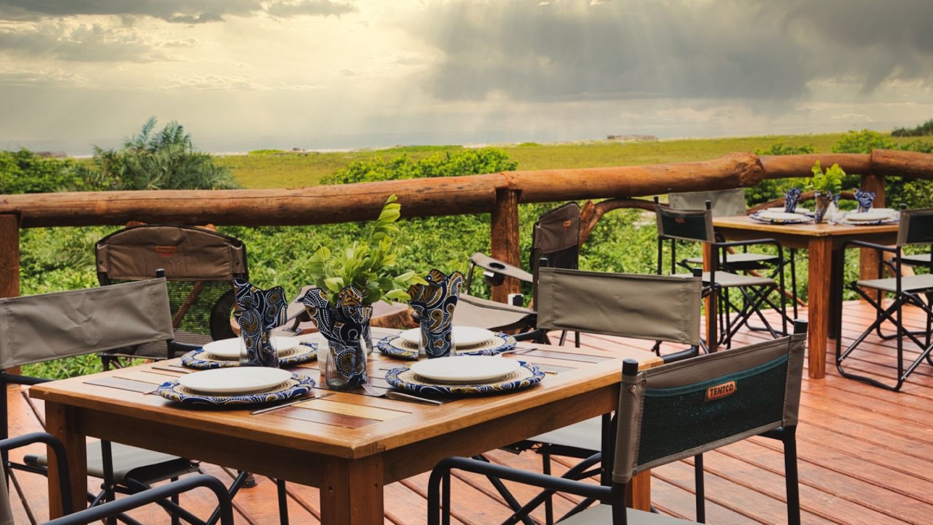 A couple of tables and chairs set for dinner overlooking views of the Gabon wilderness.