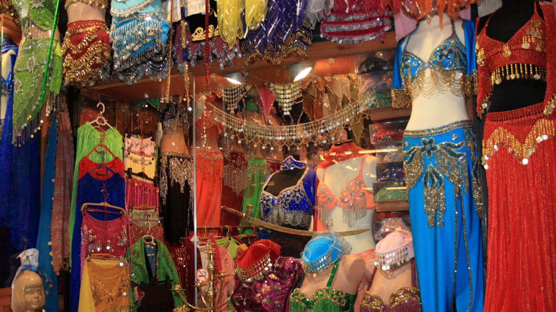 Colorful booth at a Turkish market full of traditional and elaborate clothing 
