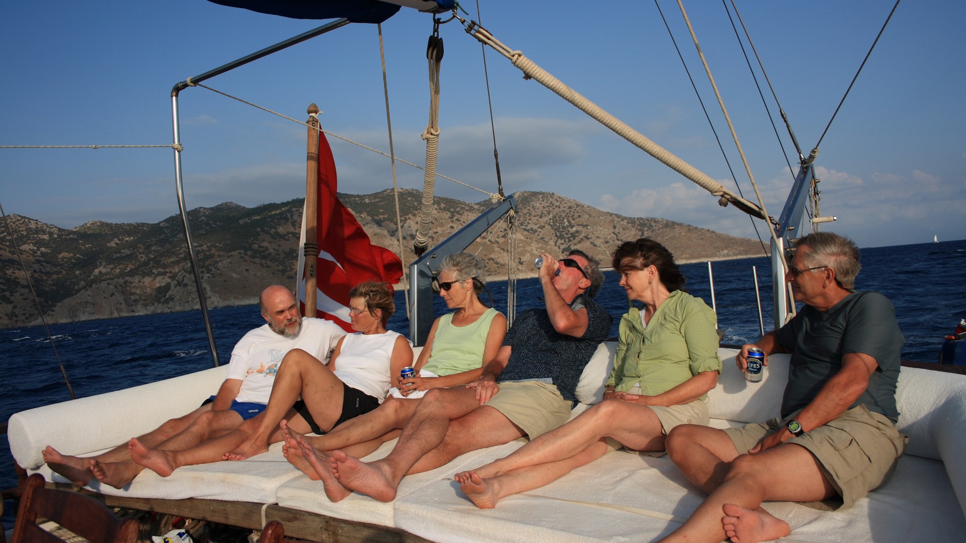 Guests enjoying a drink on the yacht deck at sunset in Turkey