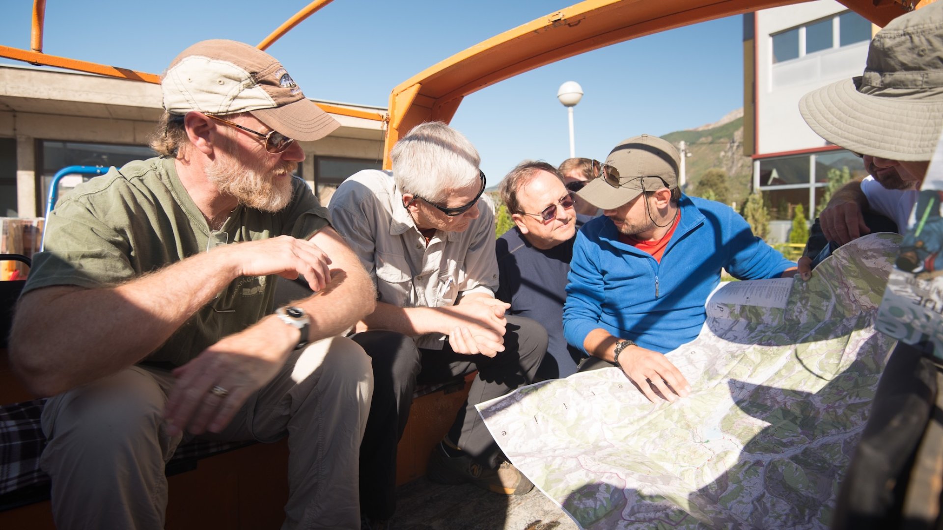 Group of travelers reviewing a map before their Albania hiking tour, preparing for an outdoor Europe hiking adventure in the Albanian Alps.