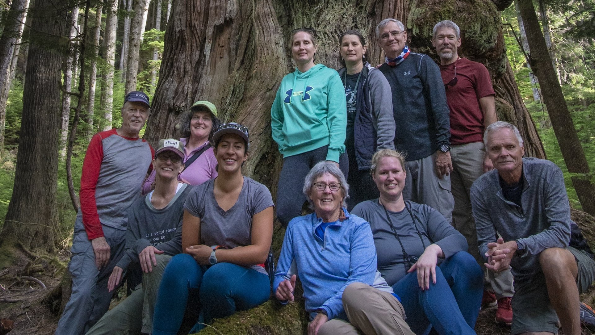 A group of tourists in the British Columbia forest smiling for a photo.