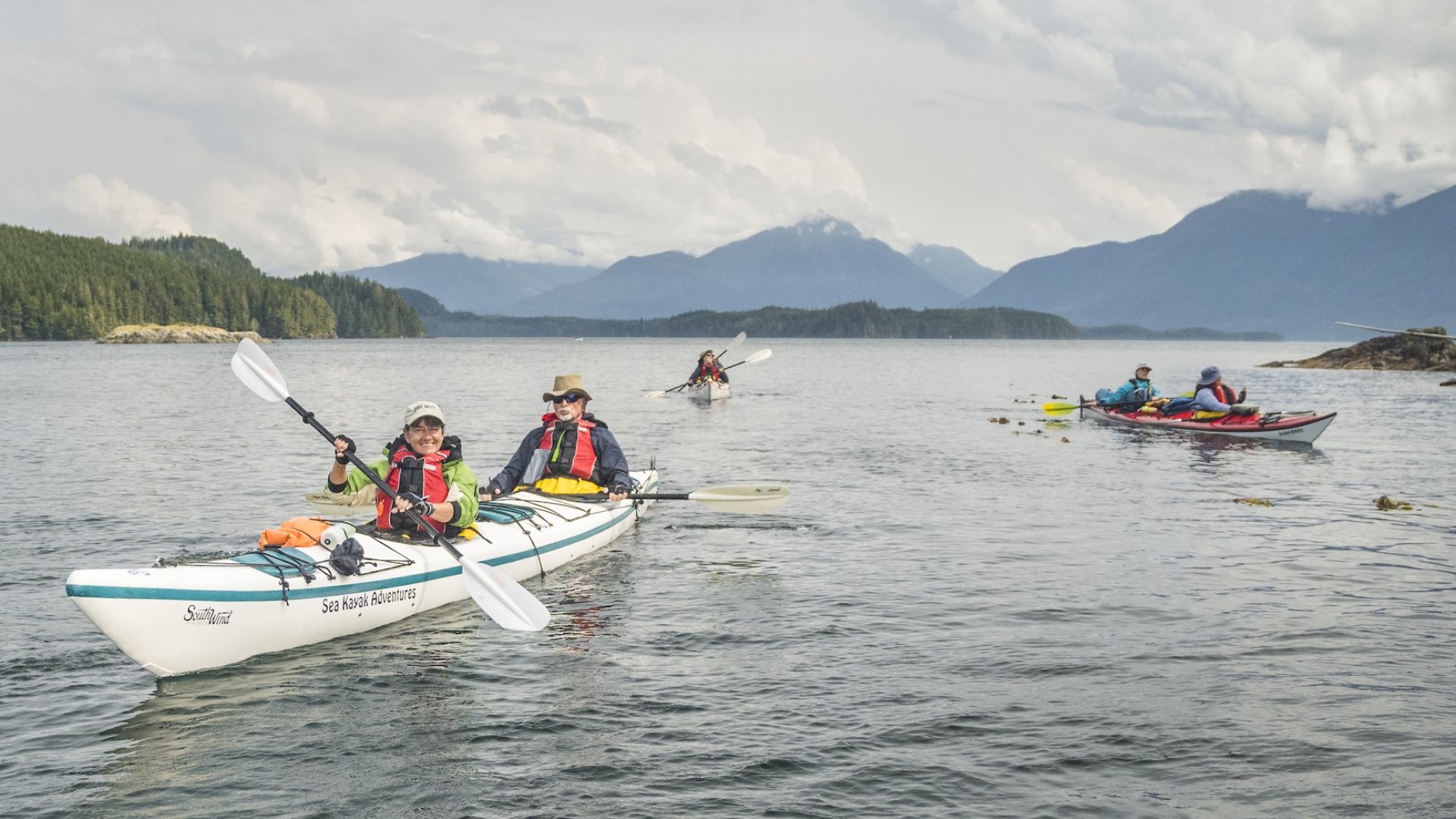 a group of sea kayakers paddling in British Columbia