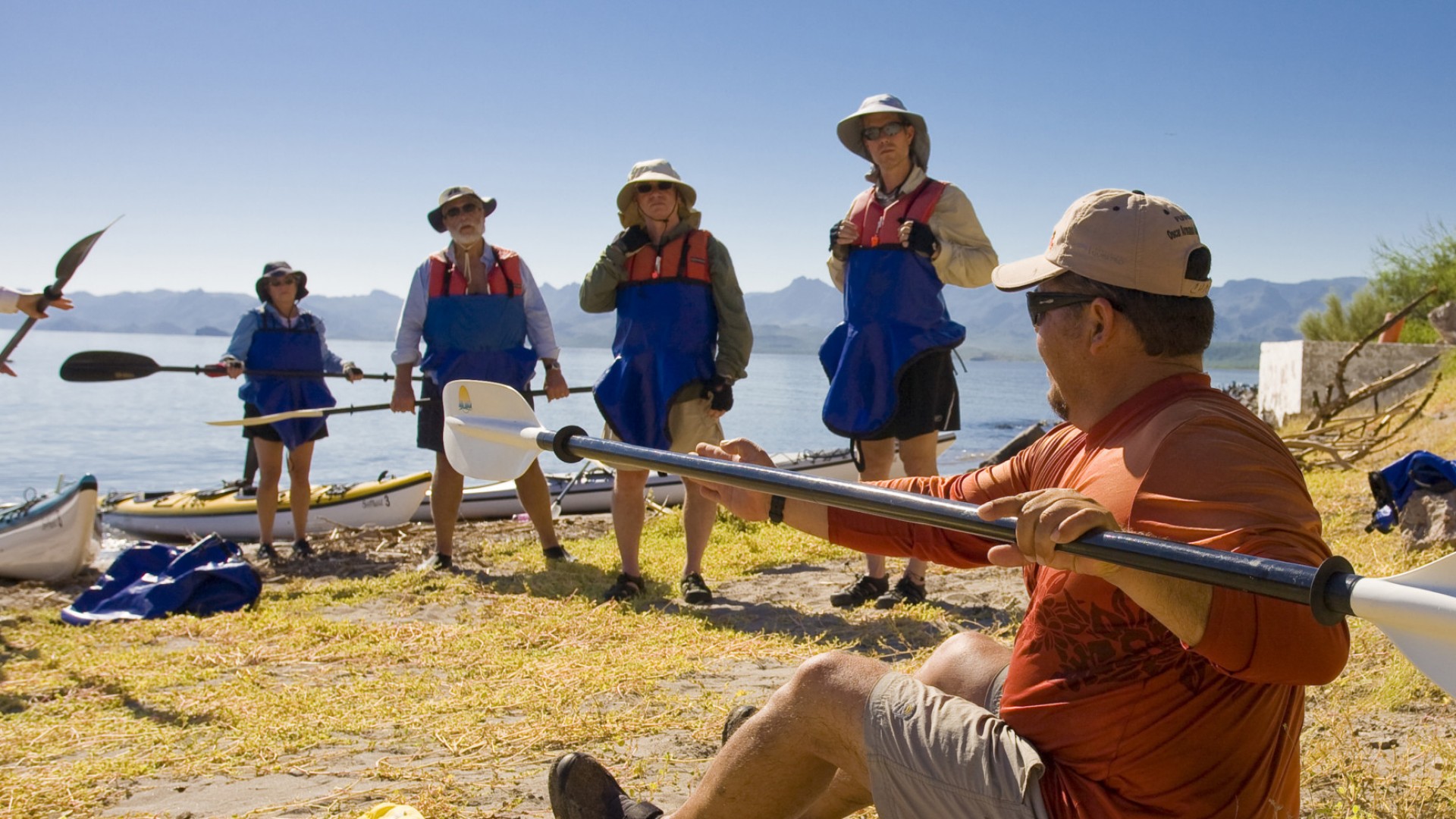 Group of guides giving a a safety and instructional talk to a group of guests before a day paddling in Baja California Sur