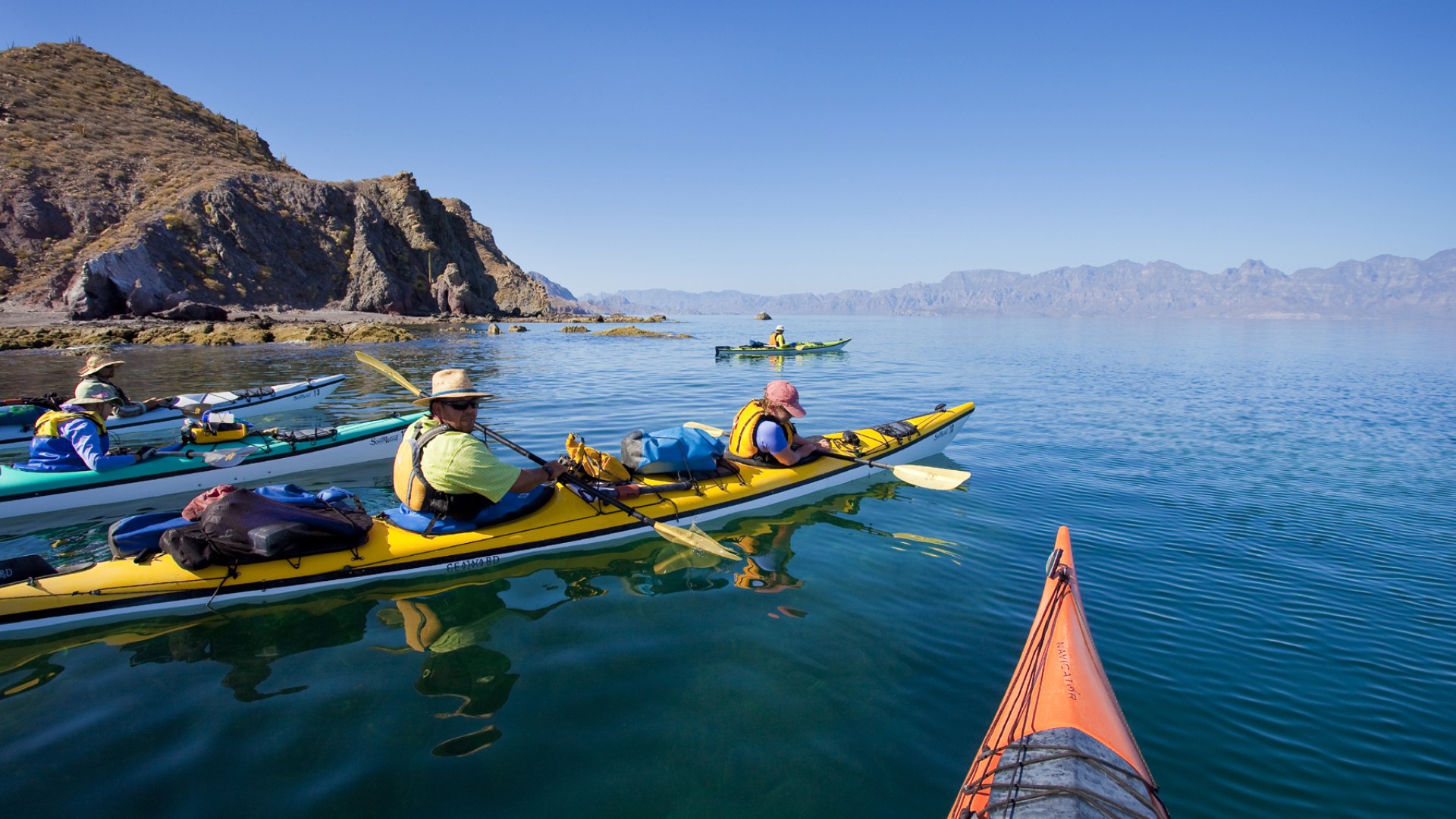 Sea kayakers looking into the Sea of Cortez for wildlife from their kayaks alongside Carmen Island in Loreto Bay National Park