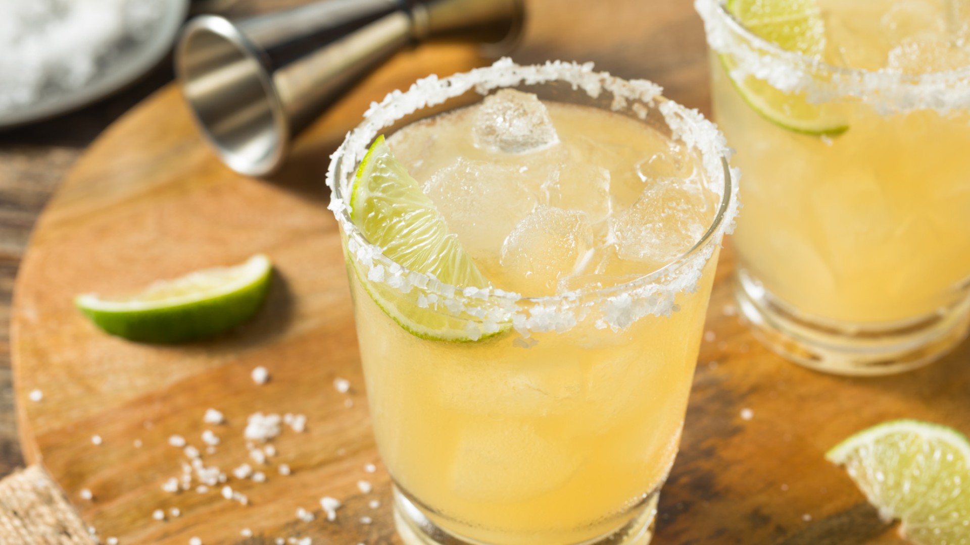 Margarita on the rocks with salt and lime on a cutting board 