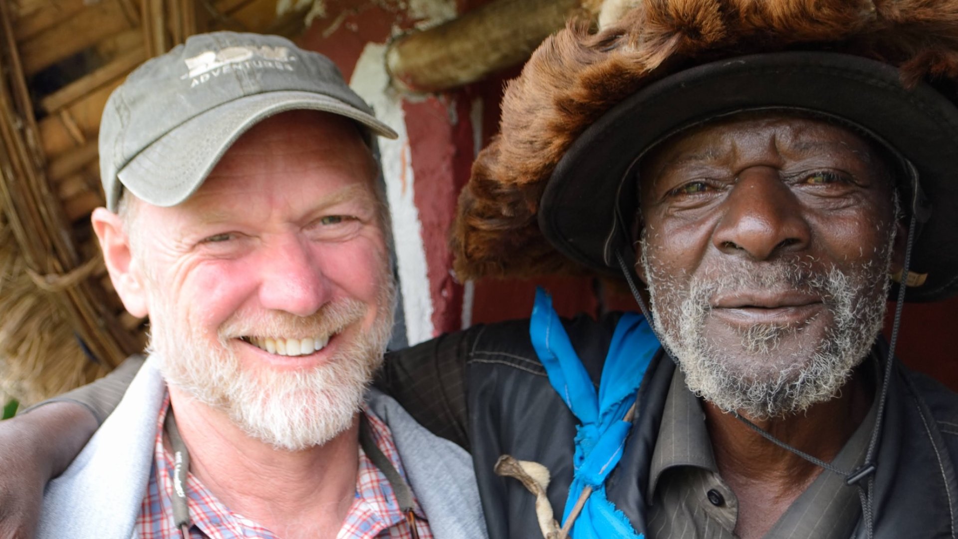 Visitor and local Rwandan guide smiling together during a community visit.