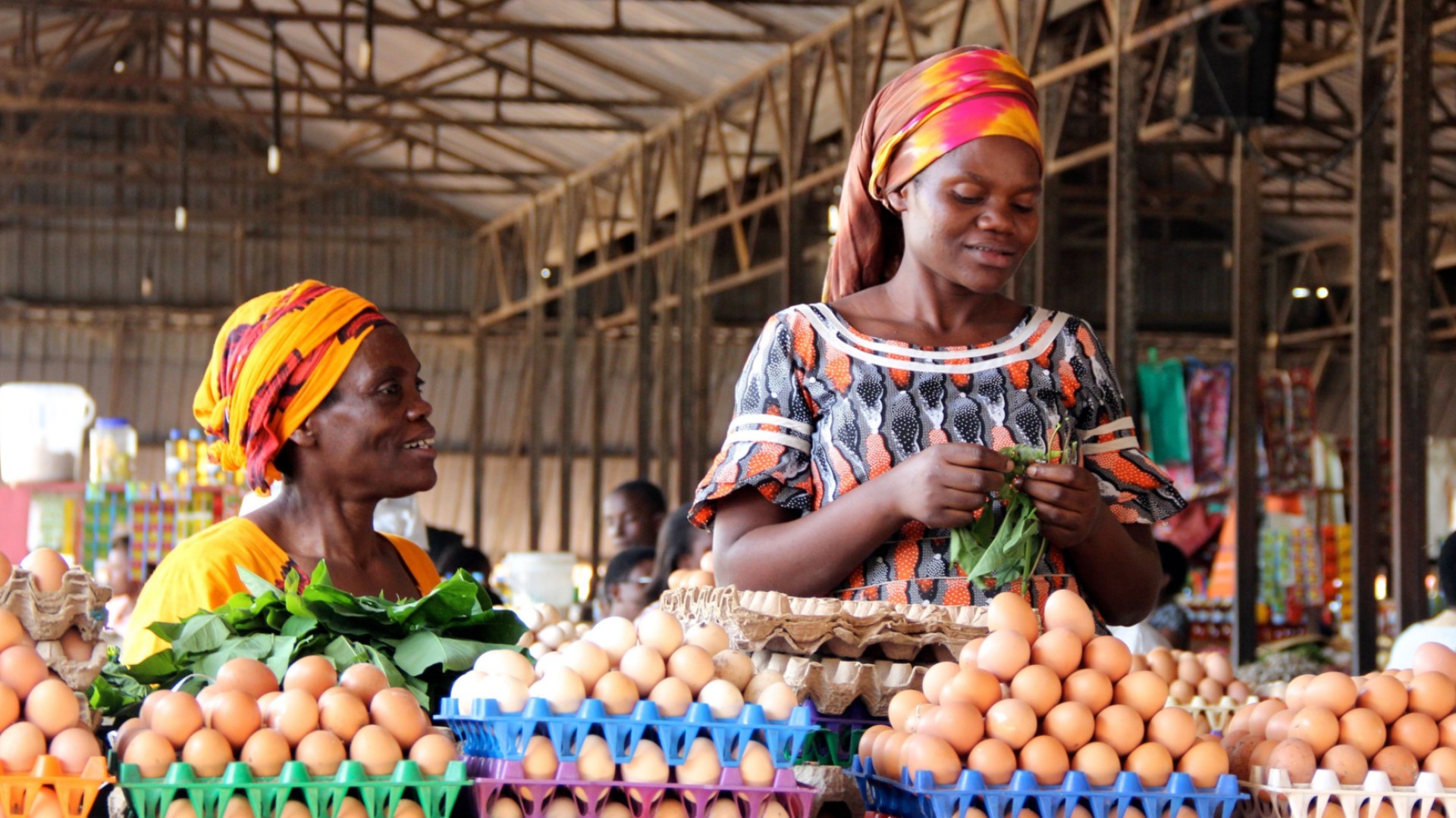 Two woman wearing head wraps and stacking eggs at the Kigali Market in Rwanda