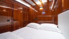 A yacht interior cabin with a neatly made bed.