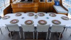 A long rectangular table with a white table cloth and traditional Turkish place settings on a yacht deck in Turkey