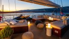 A yacht's sun deck at dusk with a view of the Adriatic Sea and mountains in the background.