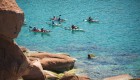 Group of sea kayakers paddling around a bend off the coast of La Paz on the Sea of Cortez