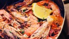Close up of a plate of cooked shrimp with a lemon wedge 