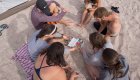 Group of kayakers sitting on the sandy beach learning about the marine wildlife in Baja