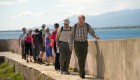 group walking along sidewalk with wall in corsica