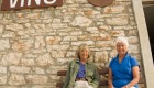 Travelers smiling in front of a cobblestone building in Montenegro