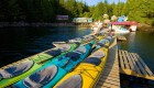 Numerous kayaks of all colors scattered across a dock at a private resort in God's Pocket Provincial Park