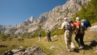 People hiking through granite and limestone mountains of Albania