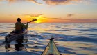 Two sea kayakers paddling into the sunrise in Baja California Sur