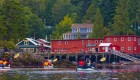 Sea kayakers paddling past a colorful port town on Vancouver Island