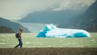 A man hiking past an iceberg in Patagonia