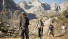 Tour group trekking through the peaks of the balkans in Albania on a sunny day
