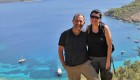 A couple smiling on top of a hike overlooking the Carian Sea behind them in Turkey