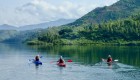 Kayakers on a lake in Rwanda admiring the lush green environment nearby
