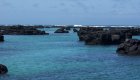 Volcanic rock proturding out of bright clear blue water in the Galapagos