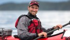 Up close of a man smiling in a red sea kayak in British Columbia