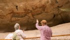 Man pointing to a petroglyph explaining the cultural and historical significance of it