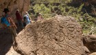 Picture of fossils and petroglyphs as tourists walk behind them