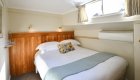 Elegant cabin with cozy bedding inside a French canal boat, offering comfort and charm while Cruising French Canals.