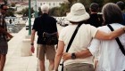 Two peoples back to the camera with their arms around each others backs walking off the dock in Croatia