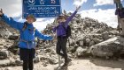 Happy hikers celebrate reaching Abra Salkantay Pass at 4,630 meters in the Peruvian Andes.